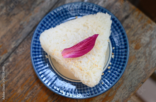 Jasmine rice served as a triangle topped with Orchid petals.