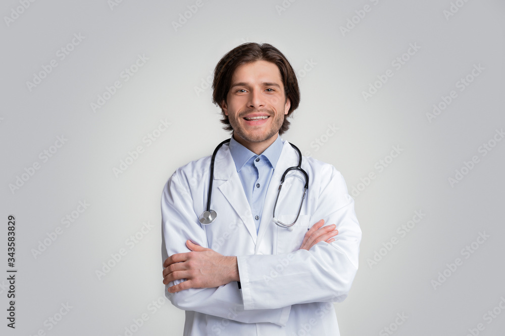 Smiling Medical Specialist Posing With Folded Arms Over White Background Smiling Medical Specialist Posing With Folded Arms Over White Background
