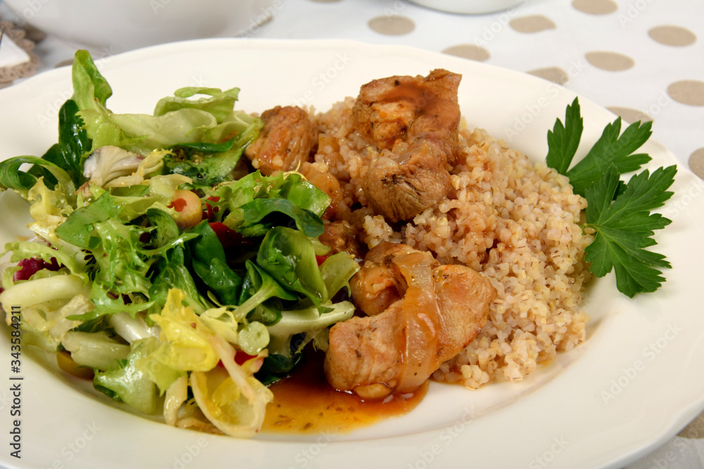 Pieces of meat on barley with sauce and lettuce from different types of lettuce Pieces of meat on barley with sauce and lettuce from different types of lettuce