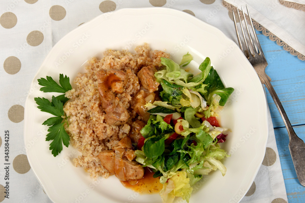 Pieces of meat on barley with sauce and lettuce from different types of lettuce Pieces of meat on barley with sauce and lettuce from different types of lettuce