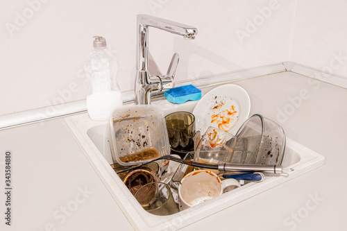 very dirty dishes lie in the sink in the kitchen