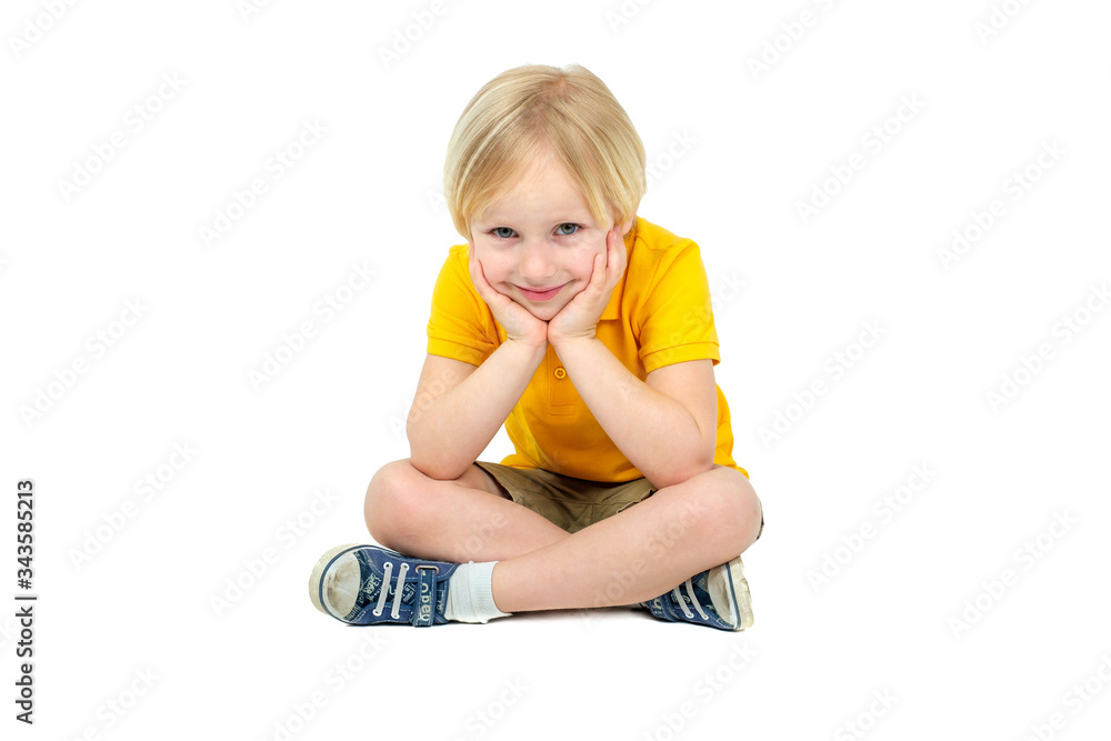 Boy sitting on floor and posing isolated on white Boy sitting on floor and posing isolated on white