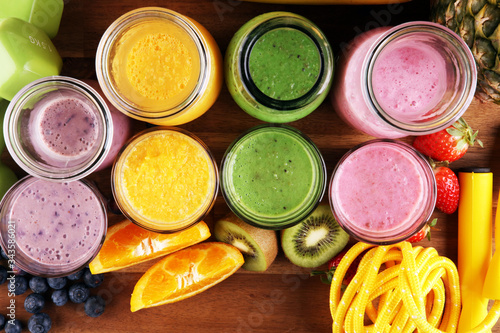 Smoothie variation. Healthy lifestyle concept. sport fitness equipment-several bottles with fruit and berry juices smoothies or milkshakes with jumping rope