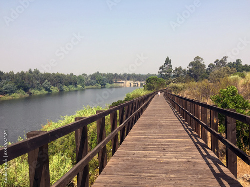 wooden footbridge in perspective on the river bank
