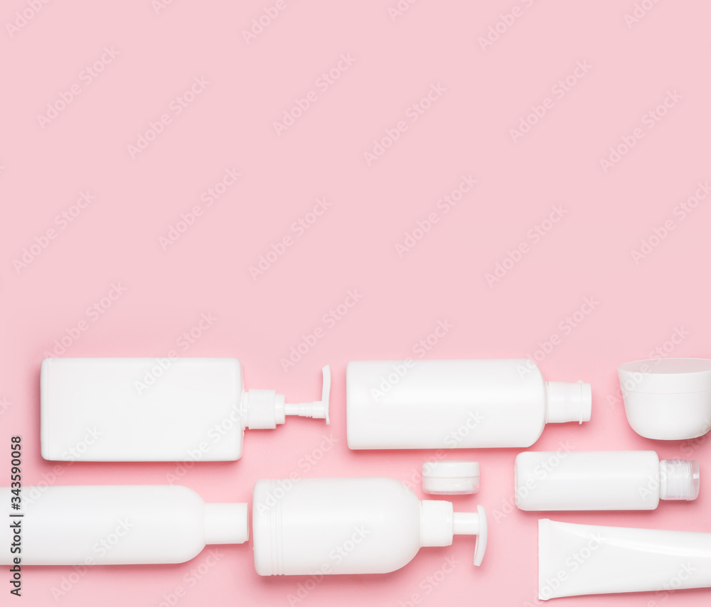 White plastic cans on a pink background. Cosmetics for skin care. Means for washing, disinfecting and washing White plastic cans on a pink background. Cosmetics for skin care. Means for washing, disinfecting and washing
