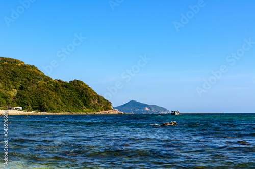 Sunny day  sand  clear turquoise sea  coral reefs on the coast of Xiaodonghai Bay in South China Sea. Sanya  island Hainan  China.