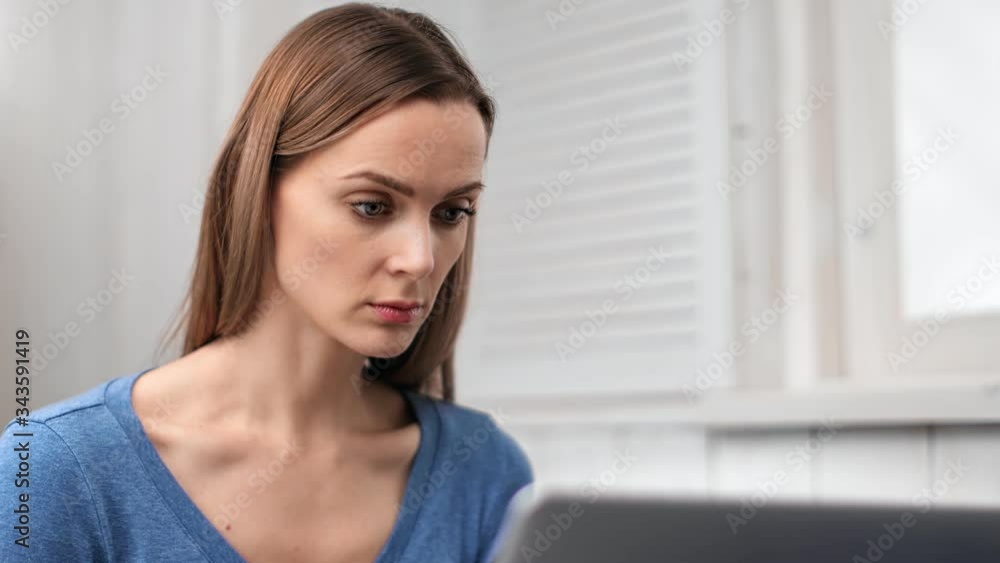 Confident face of beautiful young woman working on laptop. Close up shot on 4k RED camera Confident face of beautiful young woman working on laptop. Close up shot on 4k RED camera