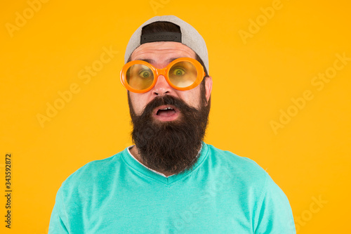 real surprise. freaky man with beard and moustache. man in funny glasses on yellow background. just have fun. party accessory. surprised man wear glasses in hipster style. male summer party fashion photo