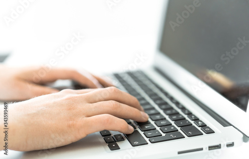 Hands writing on a Keyboard of a Laptop or Notebook in Home Office