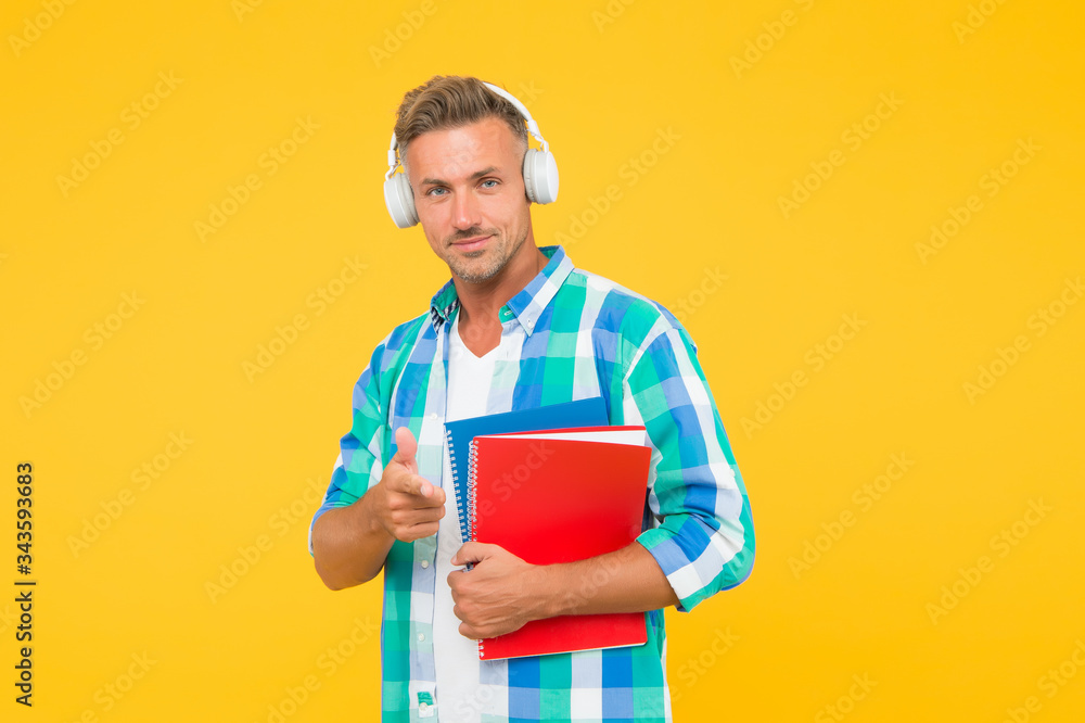 handsome university tutor pointing finger. adult student hold notebook. man with folder in headphones. online education. man hold book for notes while listen ebook. lets write in notepad handsome university tutor pointing finger. adult student hold notebook. man with folder in headphones. online education. man hold book for notes while listen ebook. lets write in notepad