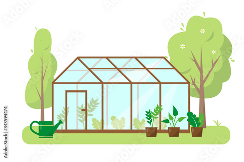 Greenhouse with plants and trees in garden.