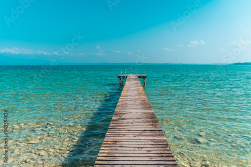 Wooden dock for boats on the light blue sea in a beatiful sommer day