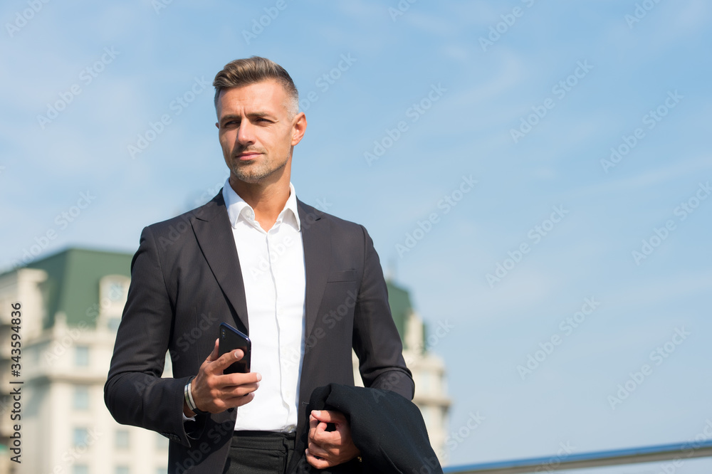 Make decisions on the go. Mobile communication. Successful and motivated business man. Businessman well groomed hairstyle. Business concept. Business life. Man classic style blue sky background Make decisions on the go. Mobile communication. Successful and motivated business man. Businessman well groomed hairstyle. Business concept. Business life. Man classic style blue sky background