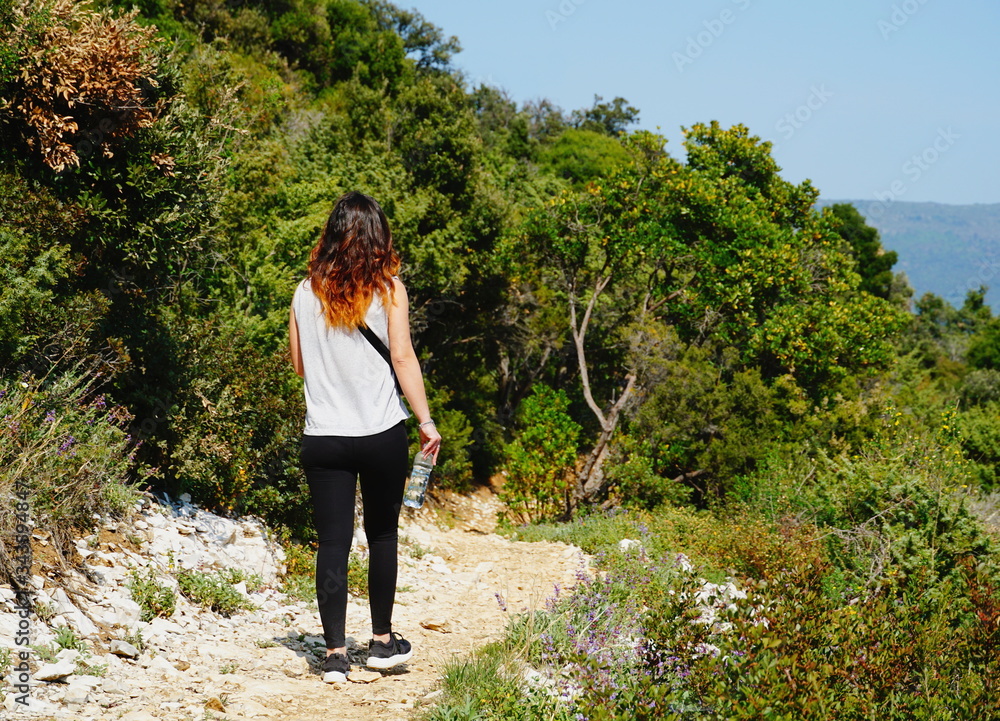 Redhead woman hiking in the colorful forest and unpolluted nature