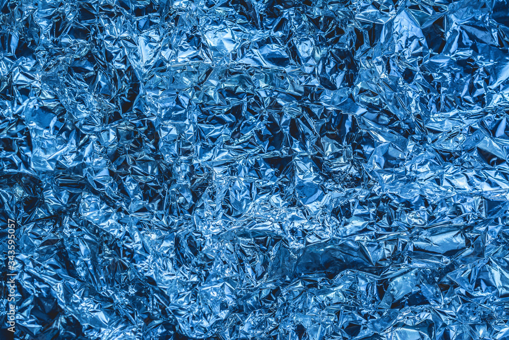 blue background of crumpled foil. shiny metal foil as a blue background or texture blue background of crumpled foil. shiny metal foil as a blue background or texture