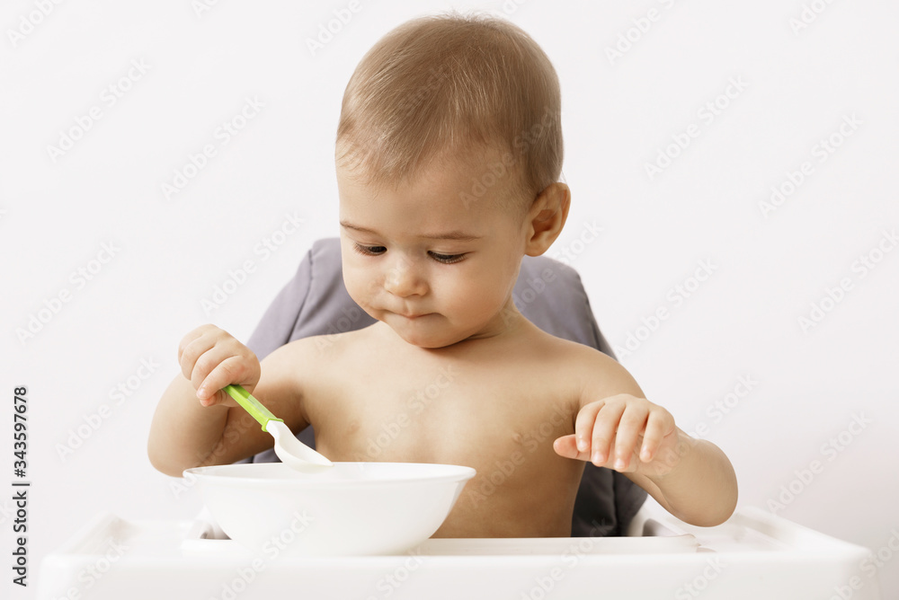 Cute hungry baby sitting in the high chair Cute hungry baby sitting in the high chair