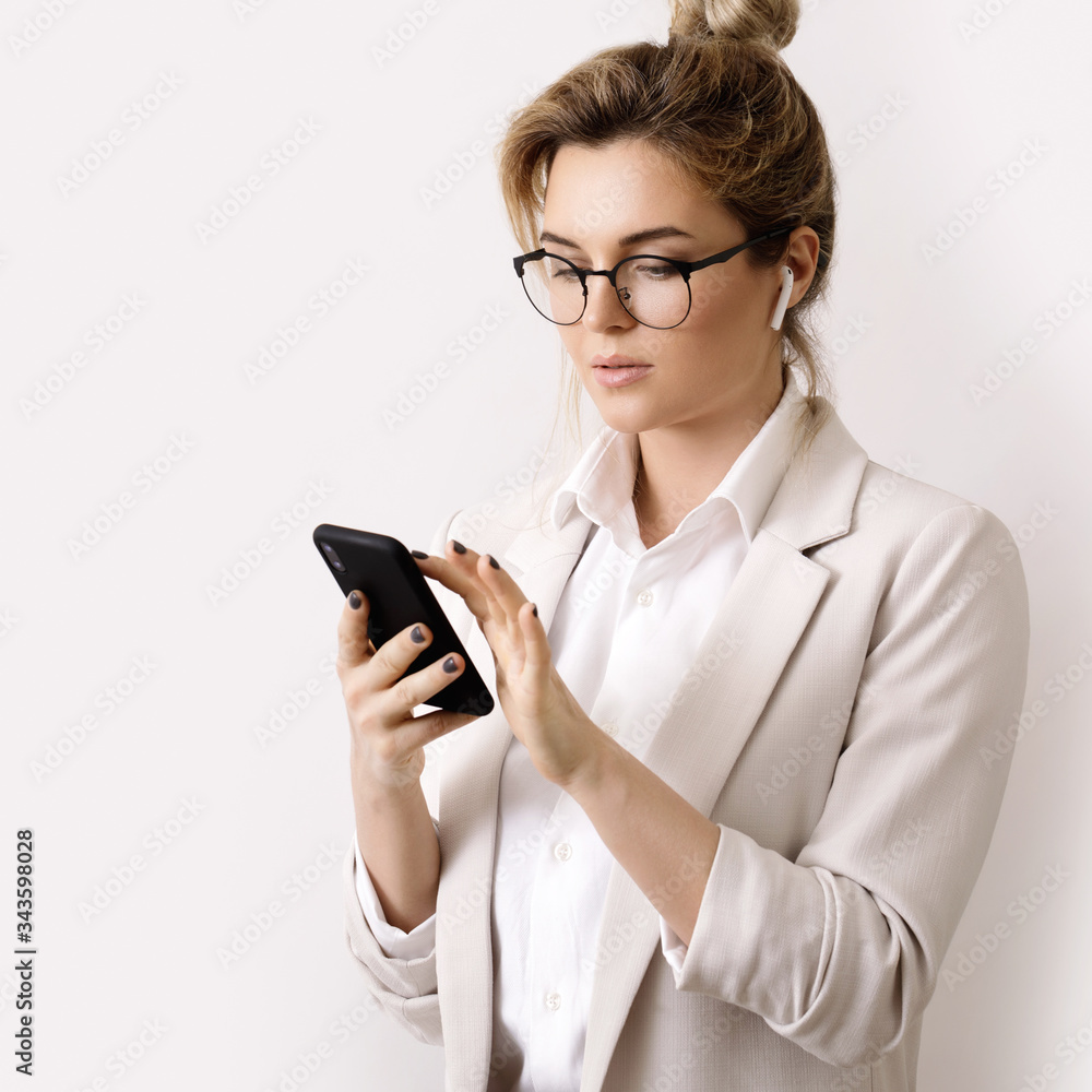 Young businesswoman talking by phone using wireless earbuds