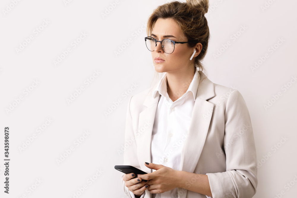 Young businesswoman talking by phone using wireless earbuds