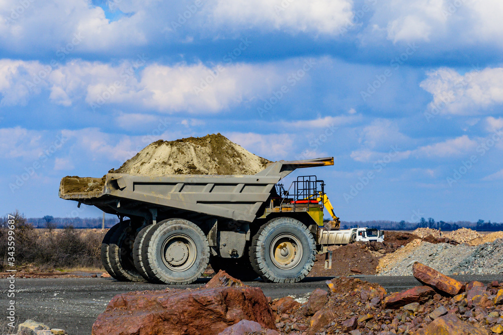 Obraz premium Huge dump truck loaded with iron ore on a gravel road