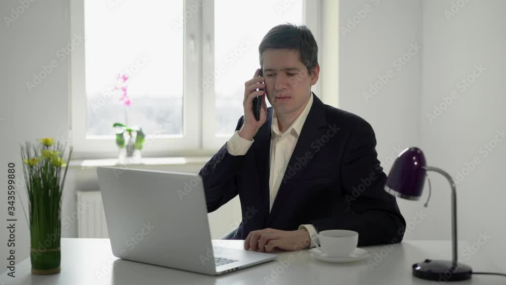 Young man working at laptop computer in office. Businessman or manager job Young man working at laptop computer in office. Businessman or manager job