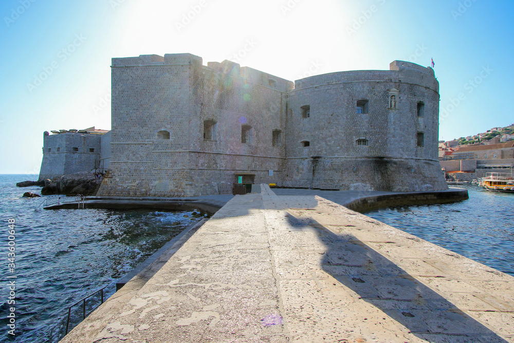 Porporela jetty at the entrance of the old port of Dubrovnik leading to Saint John's fortress that now hosts a museum and an aquarium - Walled medieval city in Croatia
