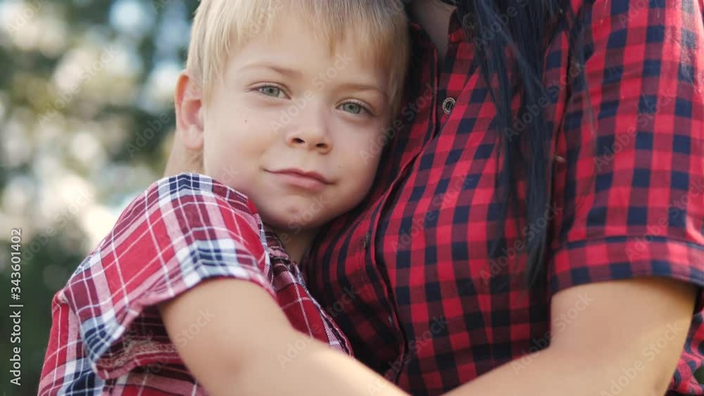 happy family mom and son sad child concept. mom tender childhood video. slow motion video. a mom brunette girl protects caress gently hugs takes care of the son lifestyle blonde boy outdoors happy family mom and son sad child concept. mom tender childhood video. slow motion video. a mom brunette girl protects caress gently hugs takes care of the son lifestyle blonde boy outdoors
