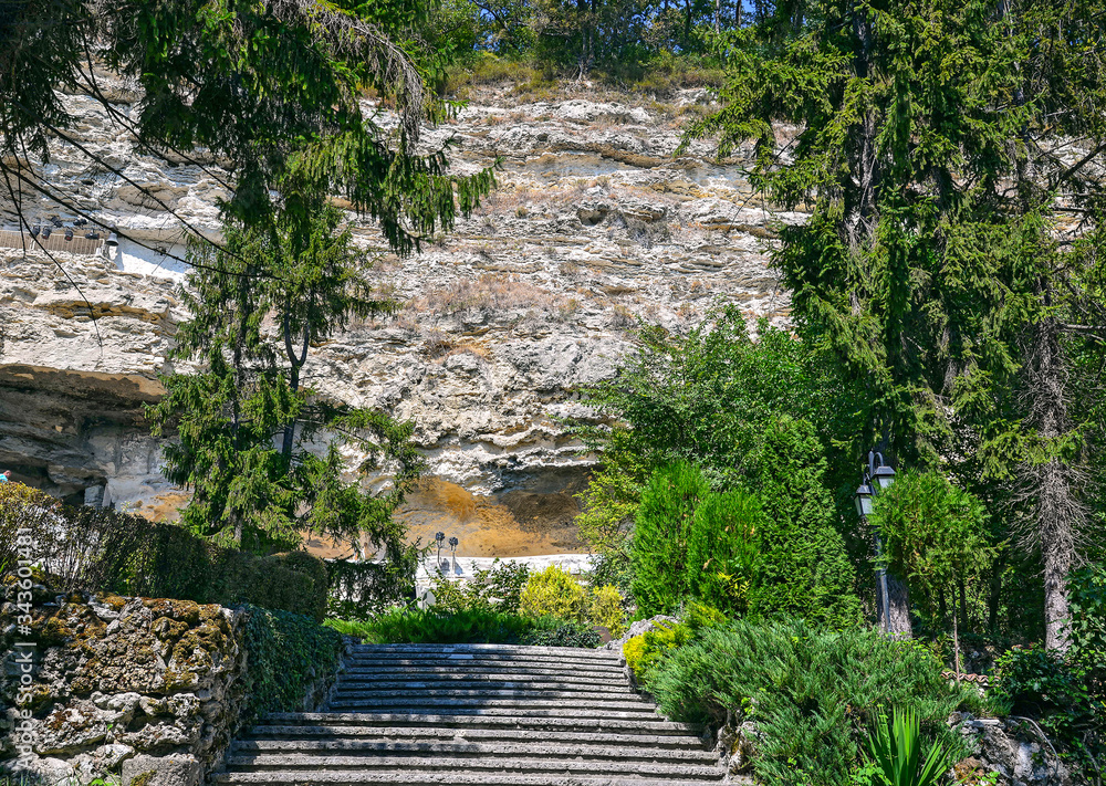 Stone stairs in a beautiful park at the foot of a high cliff