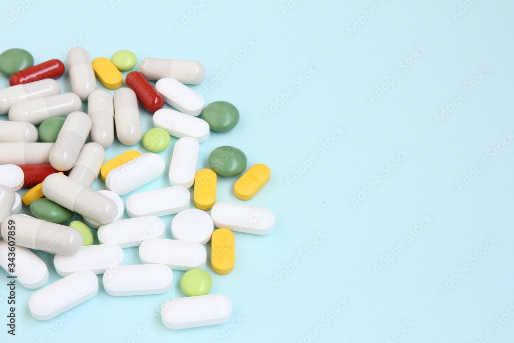 Colorful tablets scattered on a blue background - pharmaceutical - medicine for diseases