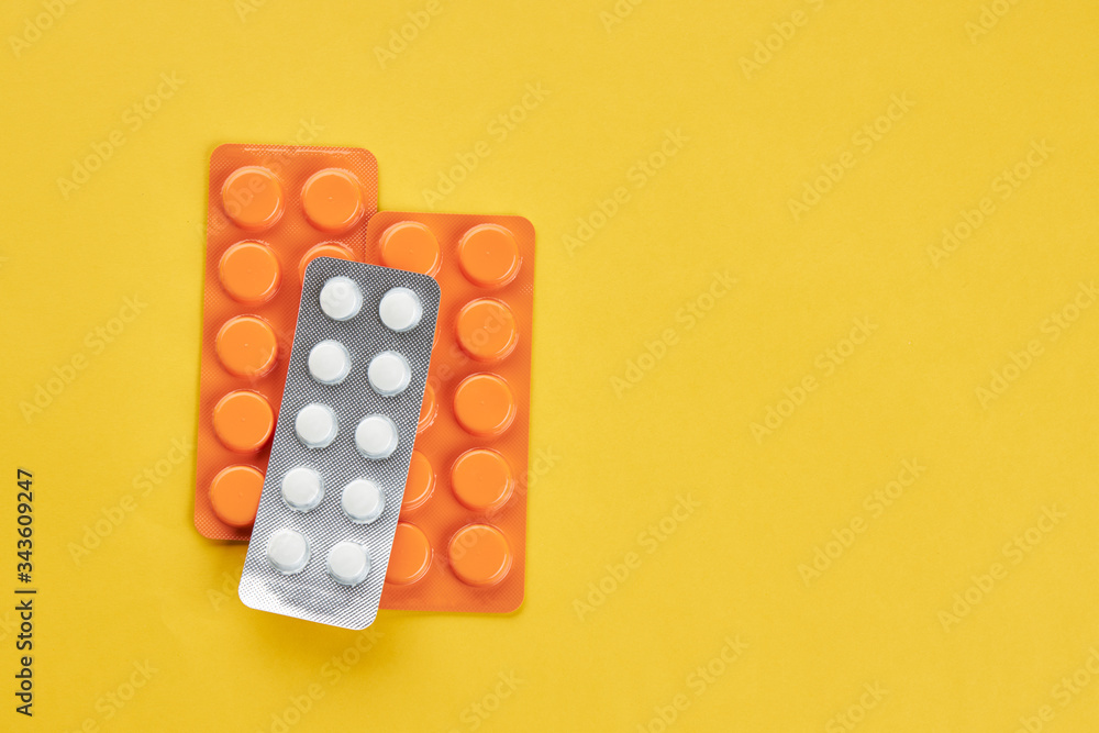 medical wellness concept. orange pills on a yellow background. copy space. minimal. medical wellness concept. orange pills on a yellow background. copy space. minimal.