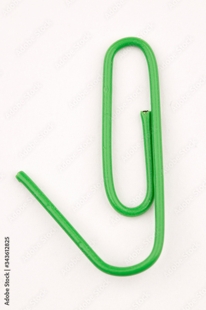 Bent green paper clip. Bent green paper clip.