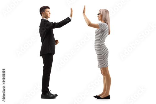 Young man in a suit gesturing high-five with a young woman