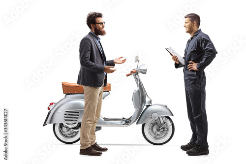 Motorcycle mechanic talking to a bearded man with a scooter
