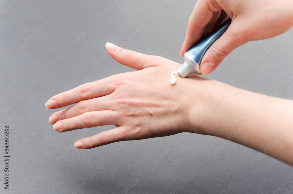 Fototapeta Skin care for female hands. Apply cream on your left hand