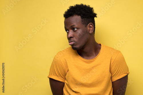 Young african american man looking down with guilty confused expression