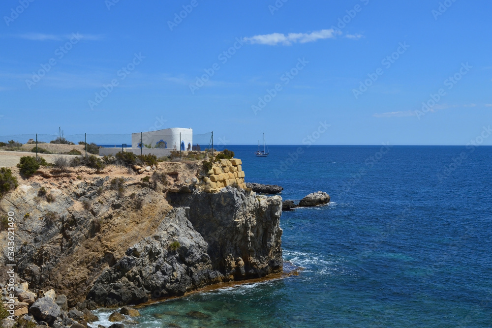 Rock cliff with building in sea