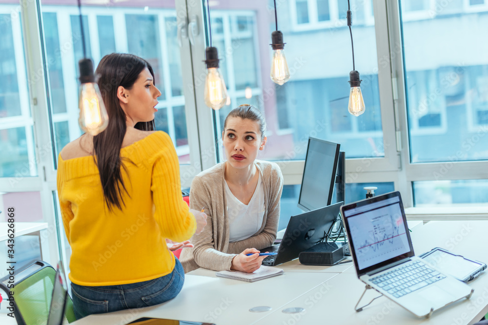 Team working on a digital project. Group of coworkers working in a startup business environment. Employees having fun in a modern office. Team working on a digital project. Group of coworkers working in a startup business environment. Employees having fun in a modern office.