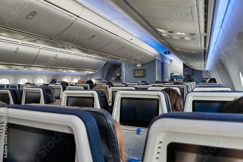 Airplane cabin interrior sold out flight full of passengers on economy class