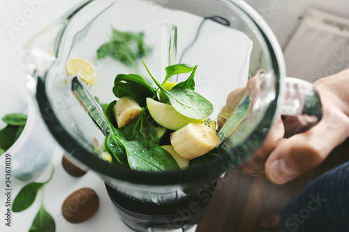 Man cooking smoothie in blender at home photo