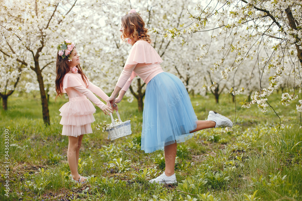 Pretty mother with daughter. Family in a spring park. Woman in a pink dress. Child with a flowers Pretty mother with daughter. Family in a spring park. Woman in a pink dress. Child with a flowers