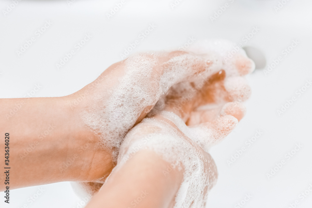 a Washing hands with soap under the faucet with water a Washing hands with soap under the faucet with water