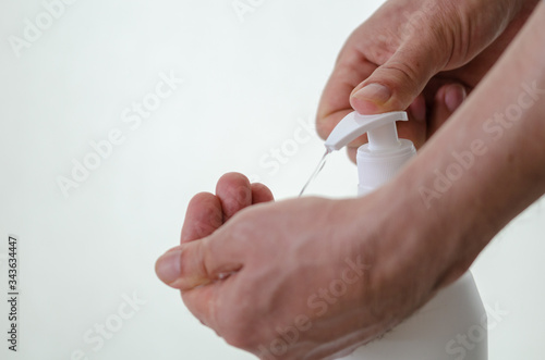 The man is pouring disinfectant to his hand