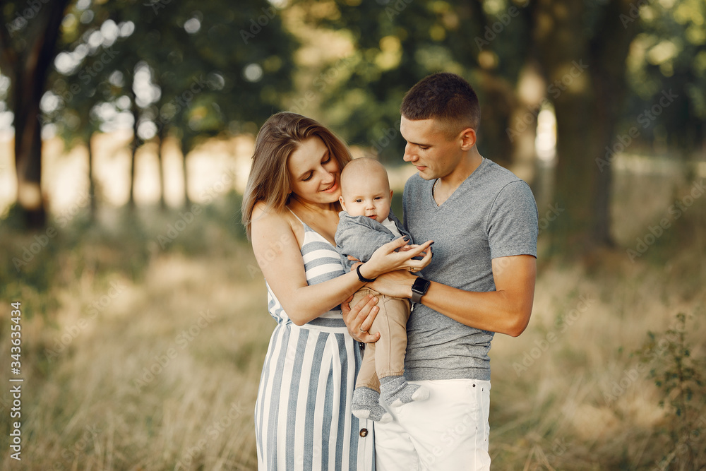 Family with cute little son. Father in a gray shirt. Lady in a dress Family with cute little son. Father in a gray shirt. Lady in a dress