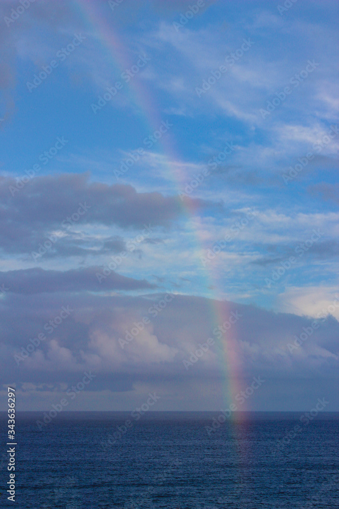 Rainbow over the ocean on a cloudy day. 