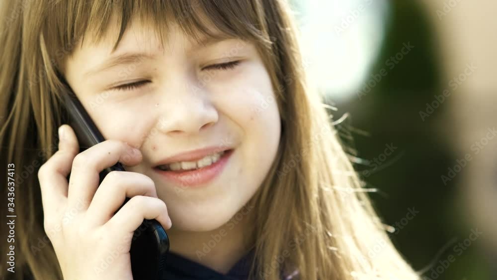 Portrait of pretty child girl with long hair talking on cell phone. Little female kid communicating using smartphone. Children communication concept. Portrait of pretty child girl with long hair talking on cell phone. Little female kid communicating using smartphone. Children communication concept.