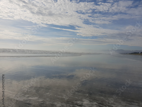 Reflections of a cloudy sky on a calm beach landscape. Waimairi Beach  Christchurch.