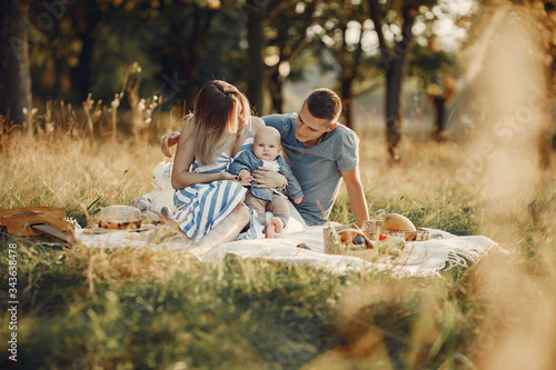 Family with cute little son. Father in a gray shirt. Family on a picnic sitting on a blanket