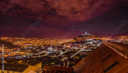 Beautiful night view of Quito mixing new architecture with charming streets, with a panecillo turist place in the mountain in front, in the city of Quito