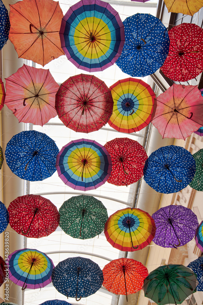 Naklejka premium A beautiful display of colourful umbrellas forming a ceiling 