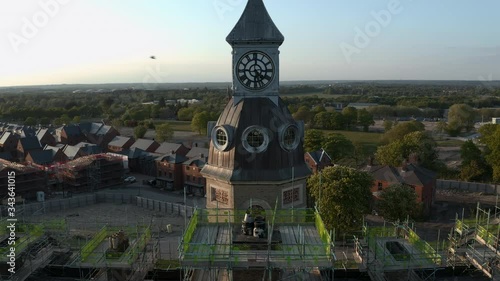 Aerial footage of military hospital clocktower being repaired during summer sunset in England