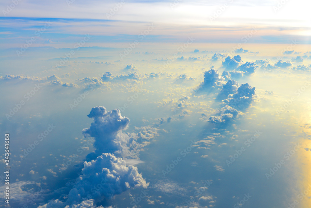 Naklejka premium Sun rise in the morning of blue sky above the white clouds and land background with golden light looking through an airplane window